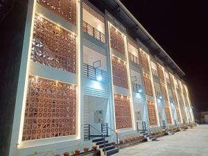 uma fila de janelas num edifício à noite em Devaki Resort em Pondicherry