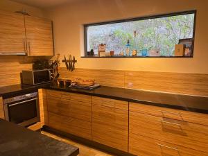 una cocina con armarios de madera y una gran ventana en Waldhaus, en Bad Sobernheim