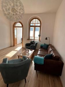 a living room with a couch and chairs and a chandelier at Ferienwohnung zur Silbertanne in Ilsenburg