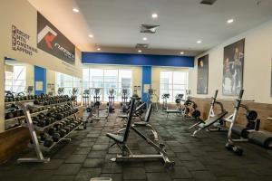 a gym with rows of exercise bikes and tread machines at 19th Floor Secure Condo with Pool, Fitness, Parking Included in Price in Skopje
