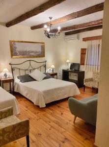 a bedroom with a bed and a desk and a chair at Hotel Restaurante Las Buitreras in El Colmenar