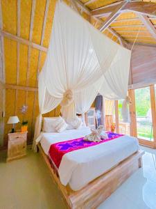 a bedroom with a large bed with a canopy at Pondok Bali Volcano in Kubupenlokan