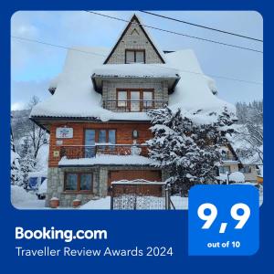 a building covered in snow with the words travel review awards at Apartamenty Harenda 39 in Zakopane