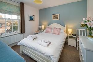 um quarto com uma cama branca e um lavatório em Hotspur House, perfectly located with sea views em Cowes