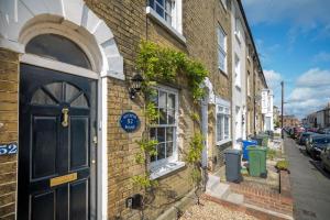 um edifício de tijolos com uma porta azul numa rua em Hotspur House, perfectly located with sea views em Cowes