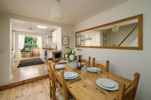 uma sala de jantar com uma mesa de madeira e um espelho em Hotspur House, perfectly located with sea views em Cowes