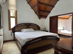 a bedroom with a large bed and a mirror at Casa Chalet en Lagos del Cacique in Bucaramanga
