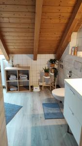 uma casa de banho com um WC branco e um tecto de madeira em FeWo am Park- mit Ausblick auf den Europa-Park em Rust