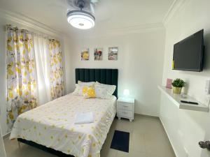 ein Schlafzimmer mit einem Bett und einem TV in der Unterkunft Ama4 Residencial AMA in Ensanche Savica de Mendoza