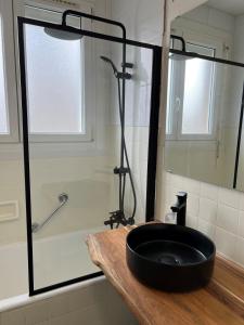 uma casa de banho com um lavatório preto e um chuveiro em COSY F3 PROCHE CENTRE em Belfort