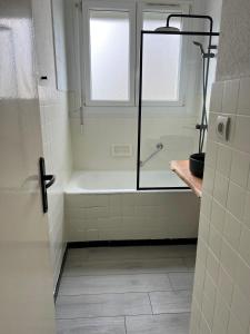 uma casa de banho com um chuveiro e uma banheira em COSY F3 PROCHE CENTRE em Belfort