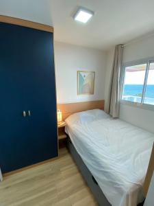 1 dormitorio con cama y ventana en Apartamento Luxuoso com Vista Mar no Smart Pituba, en Salvador