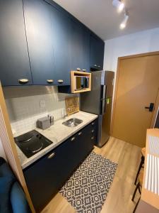 una pequeña cocina con fregadero y nevera. en Apartamento Luxuoso com Vista Mar no Smart Pituba, en Salvador