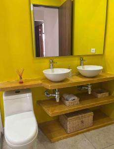 a bathroom with two sinks and a toilet and a mirror at Hotel Casa David in Rivera