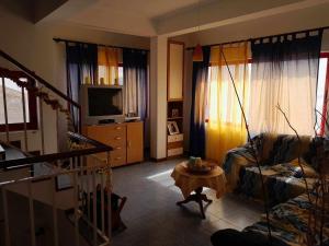 ein Wohnzimmer mit einem Sofa und einem TV in der Unterkunft Vivenda Na Baia das Gatas in Baia das Gatas