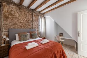マドリードにあるBNBHolder Stunning Duplex SOLのレンガの壁のベッドルーム1室(赤いベッド1台付)