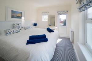 um quarto com uma grande cama branca com almofadas azuis em Fifty Two em Cowes