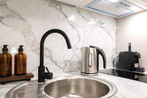 a kitchen counter with a sink with a sink at Villa Caron - Studios haut de gamme hyper centre in Rouen