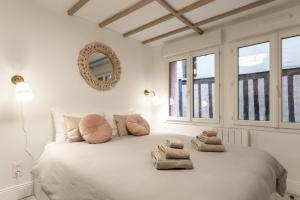 a white bedroom with a large bed with towels on it at Villa Caron - Studios haut de gamme hyper centre in Rouen