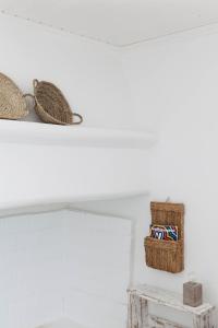 a shelf with hats and boxes on a white wall at Cucumbi in Santa Susana