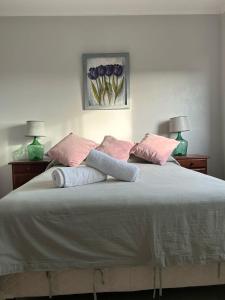 Una cama con almohadas rosas y grises. en Apartamentos en Federacion Zona Centro en Federación