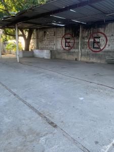 ein leerer Parkplatz mit zwei Schildern an einem Gebäude in der Unterkunft HOTEL PUERTO REAL in Paraíso