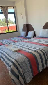 Een bed of bedden in een kamer bij HOTEL PUERTO REAL