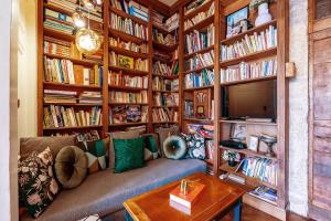 a living room filled with book shelves filled with books at Appartement Haussmannien d’Artiste, exception, quai de Saône balcon+Parking in Lyon