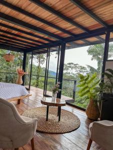 een woonkamer met een tafel en stoelen en ramen bij Cedro Amazon Lodge in Mera
