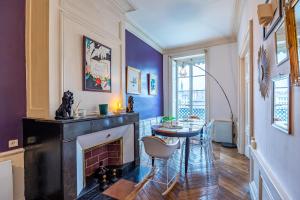 a living room with a fireplace and a table at Appartement Haussmannien d’Artiste, exception, quai de Saône balcon+Parking in Lyon