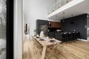 a dining room and kitchen with a table and chairs at Chalet Peak Tremblant: Your Mountain Escape. in La Conception