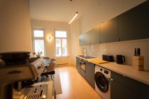 Il comprend une cuisine équipée d'un lave-linge et d'un sèche-linge. dans l'établissement Charles & Kätchen Design Zentrum, à Leipzig