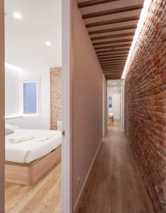 um quarto com uma cama e uma parede de tijolos em NEW, Modern and Luxurious, 3BR Apt em Madrid