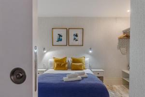 マドリードにあるBNBHolder Bright Centreのベッドルーム(青いベッド、黄色い枕付)