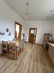 a kitchen and dining room with a table and wooden floors at Ferienwohnung zur Silbertanne in Ilsenburg