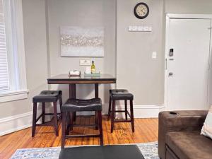 a living room with a table and stools with a bottle of wine at G4 KING BED central location museums FREE PARKING in Richmond +21 photos