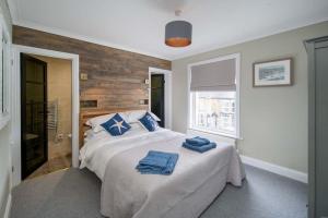 een slaapkamer met een bed met blauwe handdoeken bij Riggers Rest, stunning 3 bed home with parking in Cowes