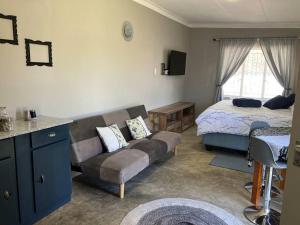 a living room with a couch and a bed at Stellies Accommodation - Room 1 in Keetmanshoop