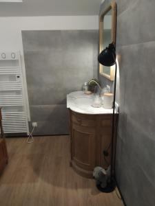 a bathroom with a sink and a black lamp at L'île d'Amélie in Ciney +43 photos