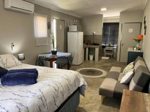 a bedroom with a bed and a couch and a kitchen at Stellies Accommodation - Room 1 in Keetmanshoop
