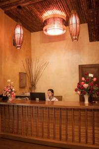 a woman sitting at a desk with a laptop at Chaipura Resort in Ko Chang