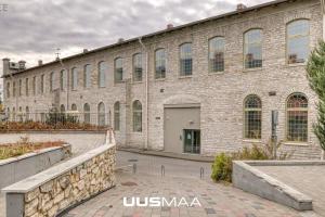 a large brick building with a stone wall at Charming loft near Old Town in Tallinn