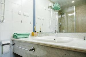 a white bathroom with a sink and a mirror at Charming loft near Old Town in Tallinn