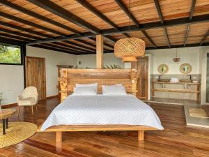 Mera的住宿－Cedro Amazon Lodge，一间卧室配有一张大床和木制床头板