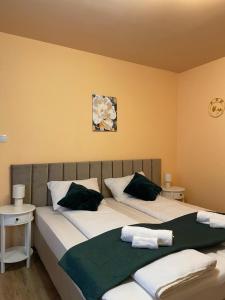 sypialnia z 2 łóżkami i białymi i zielonymi poduszkami w obiekcie Casa Făget w Klużu-Napoce