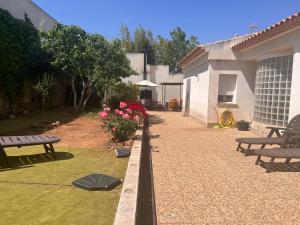 a patio with benches and flowers in a yard at Casa Laureana in Ruidera