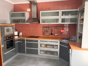 a kitchen with white cabinets and a red wall at Casa Laureana in Ruidera
