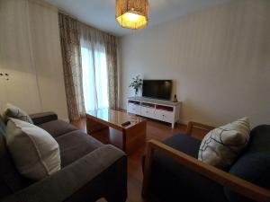 A television and/or entertainment centre at Littore TORMES con Parking, AA y Piscina
