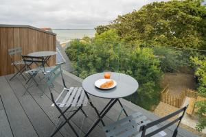une table avec une assiette de nourriture sur un balcon dans l'établissement Rotherwood, Gurnard Seafront, à Gurnard