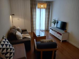 A television and/or entertainment centre at Littore TORMES con Parking, AA y Piscina